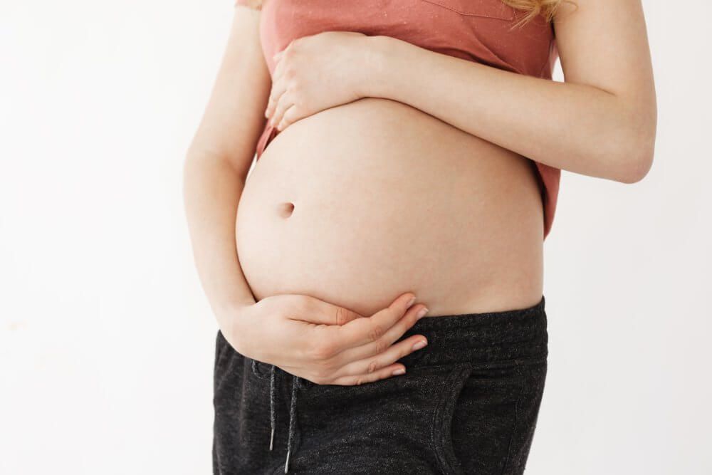 cinta-kinesiologica-cerrar-detalle-joven-bella-madre-sosteniendo-su-vientre-embarazado-manos